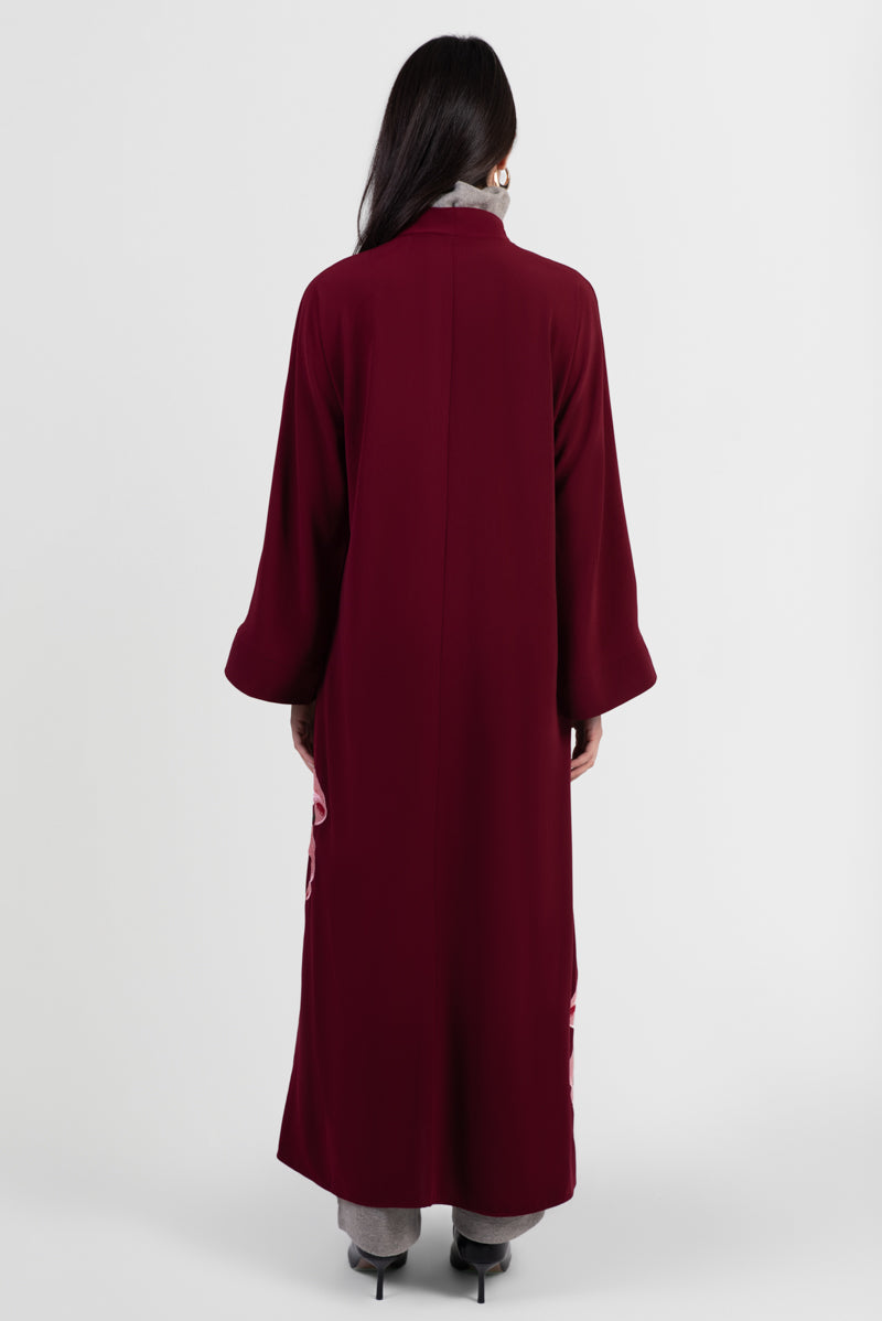 Burgundy abaya with pink lily embroidery around bottom hemline back view
