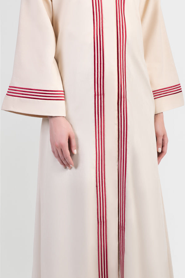 Beige linen abaya with red stripes running vertically around front placket and sleeve cuffs details