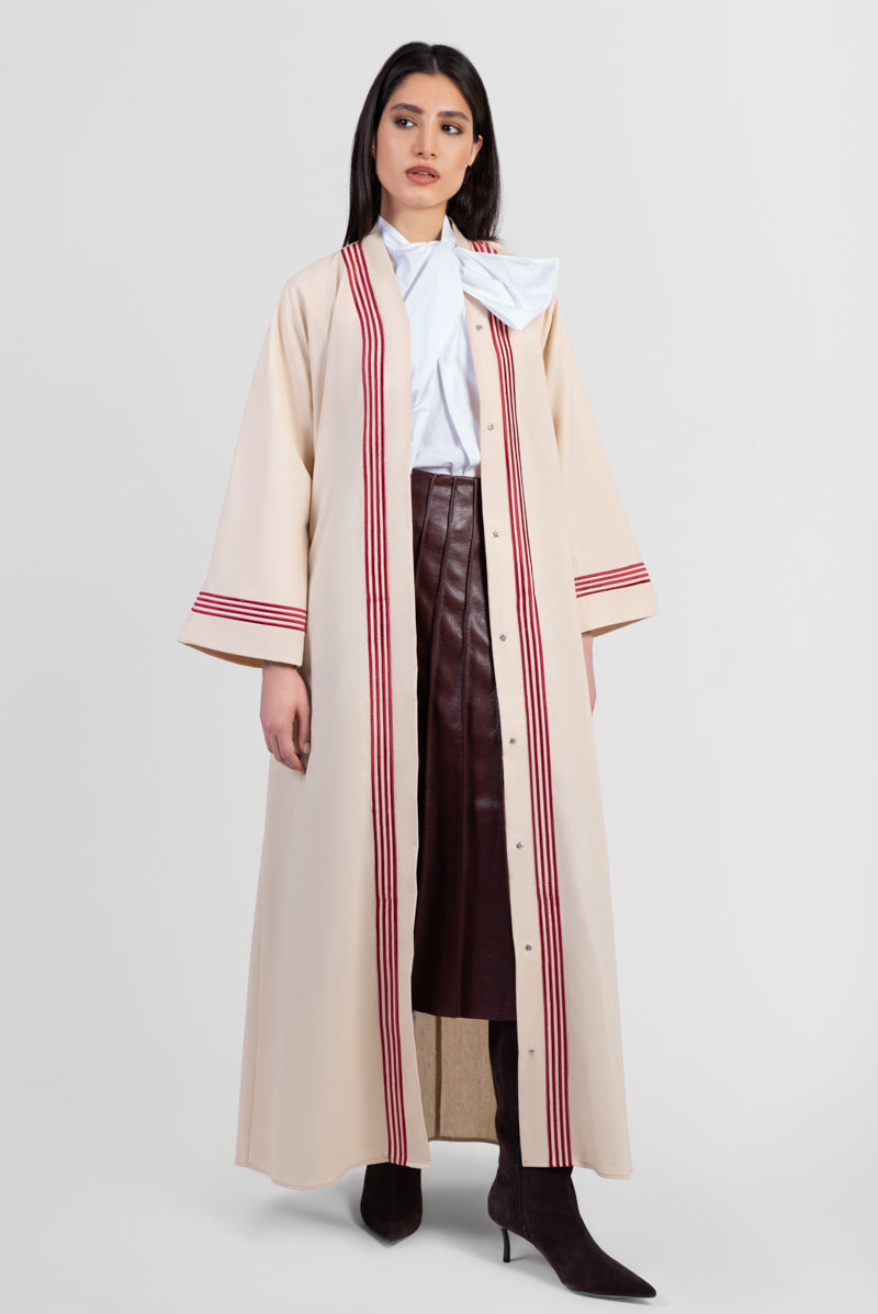 Beige linen abaya with red stripes running vertically around front placket and sleeve cuffs open front view