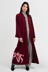 Burgundy abaya with pink lily embroidery around bottom hemline open front